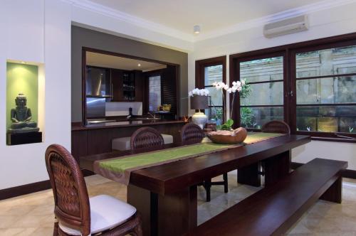 a dining room with a wooden table and chairs at Villa Ocean in Tanah Lot