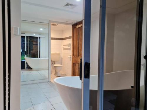 a bathroom with a tub and a toilet and a sink at Cosy Studio Walk to Bondi and Bronte Beaches in Sydney