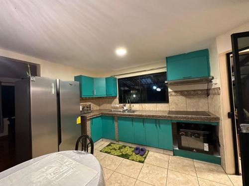 una cocina con armarios azules y electrodomésticos verdes en Villa_angelita, 