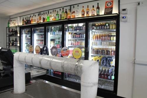 un frigorifero pieno di bottiglie di alcol di Pally Pub 