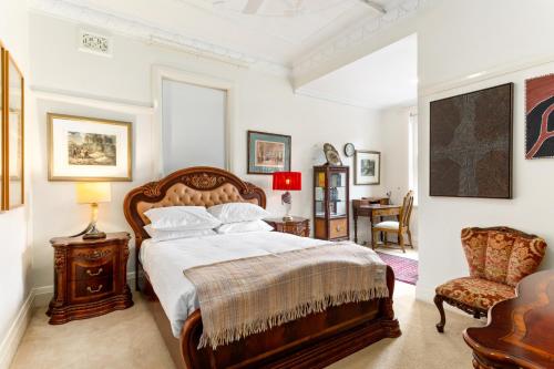 a bedroom with a bed and a chair at Eclectic Art Deco Apartment in great location in Sydney