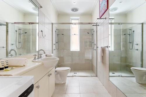 a bathroom with a shower and a toilet and a sink at Eclectic Art Deco Apartment in great location in Sydney