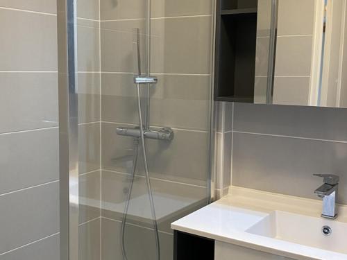 une douche avec une porte vitrée à côté d'un lavabo dans l'établissement Appartement 3 pièces calme avec ascenseur à Dives-sur-Mer - FR-1-487-319, à Dives-sur-Mer