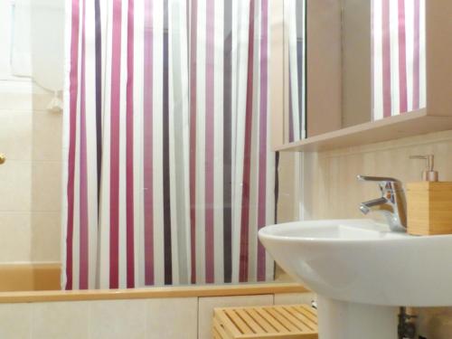 une salle de bain avec un lavabo et un rideau de douche dans l'établissement Maison Cozy au Coeur de Cabourg avec Terrasse, Proche Plage, pour 4 Pers., Animaux Acceptés - FR-1-487-328, à Cabourg