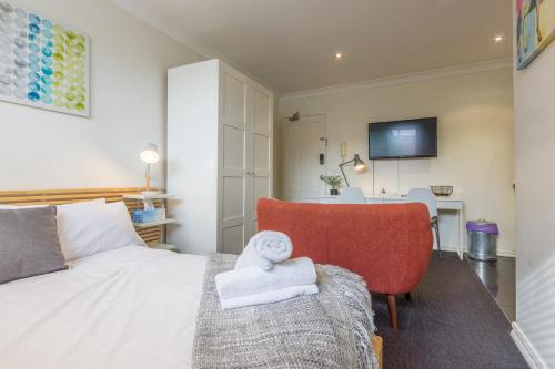um quarto com uma cama, uma cadeira e uma mesa em Studio Apartment in the heart of Fitzroy em Melbourne