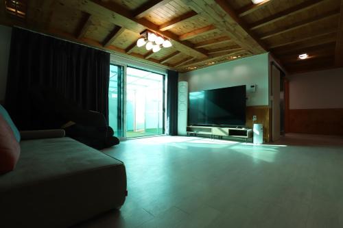 a living room with a couch and a flat screen tv at Z Hotel in Cheongju