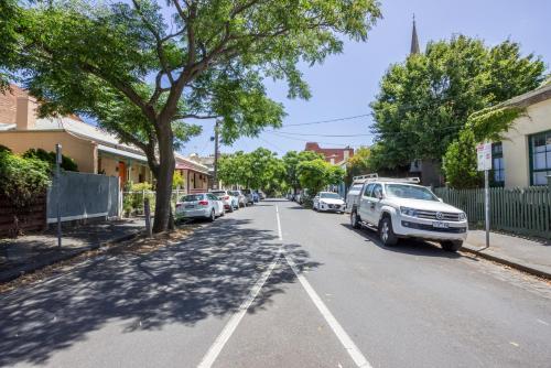 a street in a town with cars parked at Funky Fitzroy apartment so close to the action in Melbourne