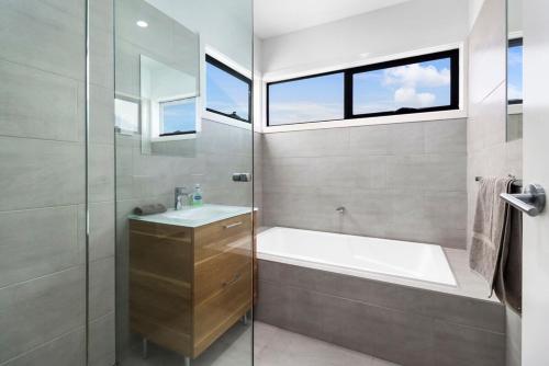 y baño con bañera, lavamanos y ducha. en Raven West House I Corporate or Holiday en Geelong West