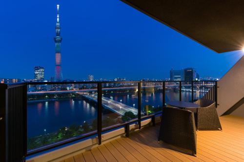 einen Balkon mit Blick auf die Skyline der Stadt in der Unterkunft stayme THE HOTEL Asakusa Riverside in Tokio