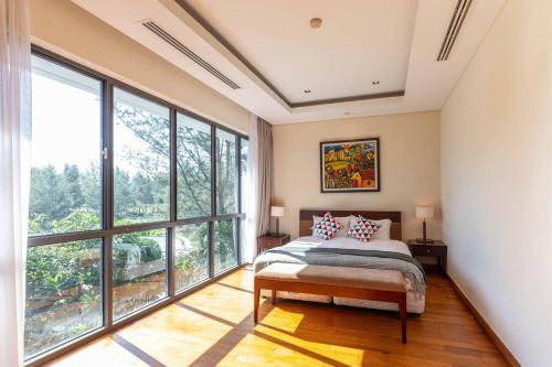 um quarto com uma cama e janelas grandes em The Ocean Villa Đà Nẵng em Da Nang