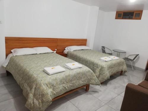 オクサパンパにあるExcelente ubicación! Bellas y cómodas habitaciones en el centro de Oxapampaのベッド2台が隣同士に設置された部屋です。