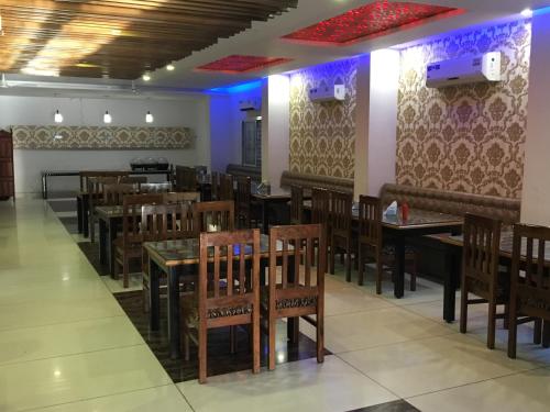 a restaurant with tables and chairs in a room at Hotel Trihari in Rishīkesh