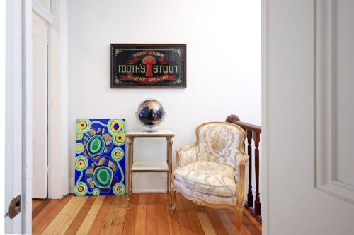 a room with a chair and a picture on the wall at Charming 3-Bedroom Terrace in the Heart of Glebe in Sydney