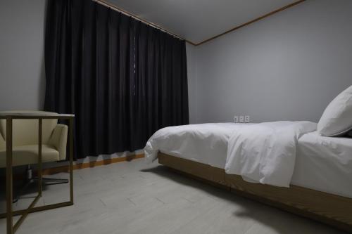 a bedroom with a bed and a table and a chair at Z Hotel in Cheongju