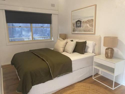 a bedroom with a bed and a window at Terrigal Coastal Casa in Wamberal