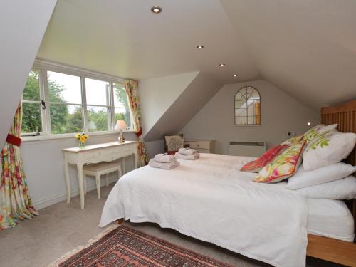 a bedroom with a large white bed and a desk at 2 Bed in Beaminster 63136 in Stoke Abbott