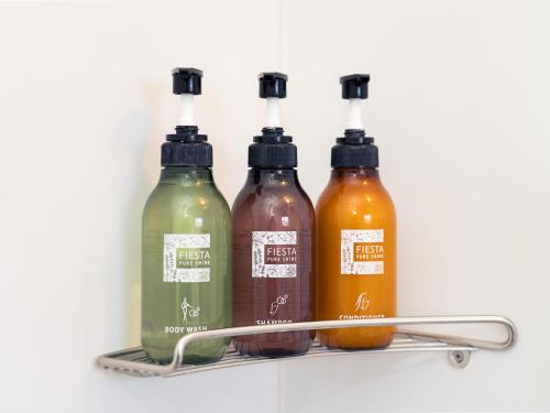 a group of four bottles of sauce on a shelf at You Style Hotel MARINE in Kagoshima