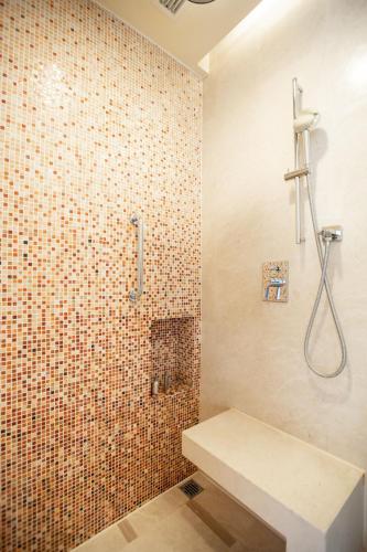 a bathroom with a shower with a bench in it at The Imperial Mansion, Beijing - Marriott Executive Apartments in Beijing
