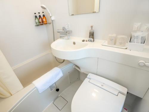 a white bathroom with a sink and a toilet at You Style Hotel MARINE in Kagoshima
