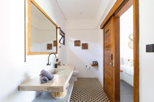 W łazience znajduje się umywalka i lustro. w obiekcie Villa Sea La Vie Bingin w mieście Uluwatu