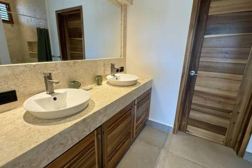 Un baño con dos lavabos y un espejo grande. en Exquisite Private Villa, en Las Terrenas