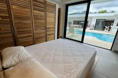 1 dormitorio con 1 cama y vistas a la piscina en Exquisite Private Villa, en Las Terrenas