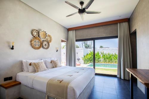 sypialnia z łóżkiem i wentylatorem sufitowym w obiekcie Villa Sea La Vie Bingin w mieście Uluwatu