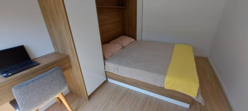 a small bedroom with a bed and a laptop at Villa Krivokapic in Trebinje