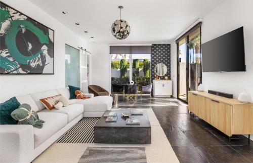 a living room with a white couch and a tv at Private Pool & Mountain Views! in Palm Springs