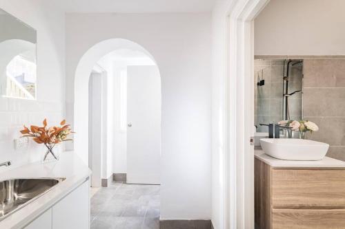 a white bathroom with a sink and a mirror at Waterfront - KING Bed Suite @ Rocks Sydney #10A in Sydney