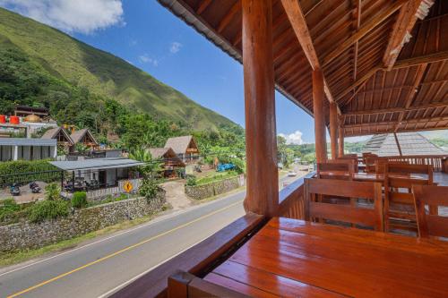 a porch with a view of a street and a mountain at Teras Sawah Guest House Syariah in Sembalun Lawang