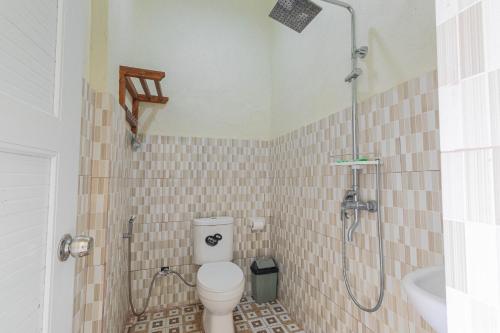 a bathroom with a shower and a toilet and a sink at Teras Sawah Guest House Syariah in Sembalun Lawang