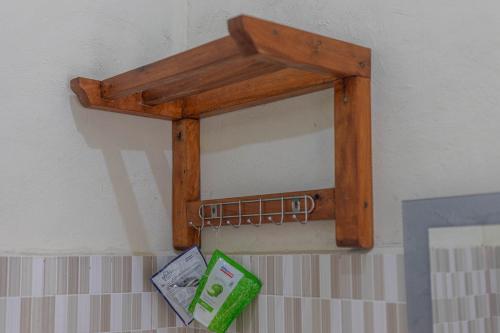 a wooden mirror hanging on a wall with money at Teras Sawah Guest House Syariah in Sembalun Lawang