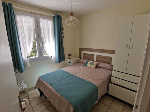 Schlafzimmer mit einem Bett, einer Kommode und Fenstern in der Unterkunft Maison La Tranche-sur-Mer, 3 pièces, 5 personnes - FR-1-194-12 in La Tranche-sur-Mer