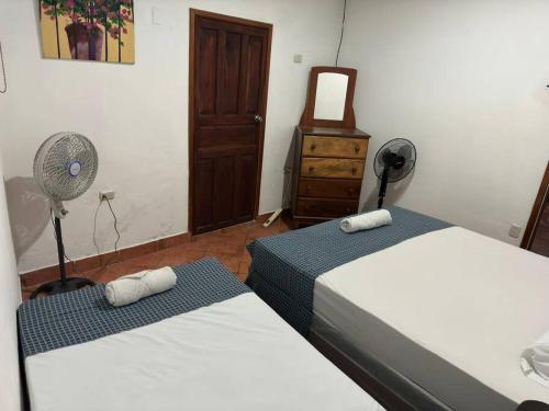 グラナダにあるApartamento Nilxonのベッドルーム1室(ベッド2台、ファン、ドレッサー付)