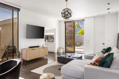 a living room with a couch and a flat screen tv at Private Pool & Mountain Views! in Palm Springs