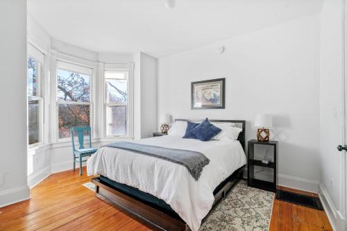 Maple Manor في سانت بول: غرفة نوم بيضاء بسرير وكرسي ازرق