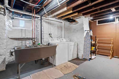 a laundry room with a washing machine and a sink at Maple Manor in Saint Paul