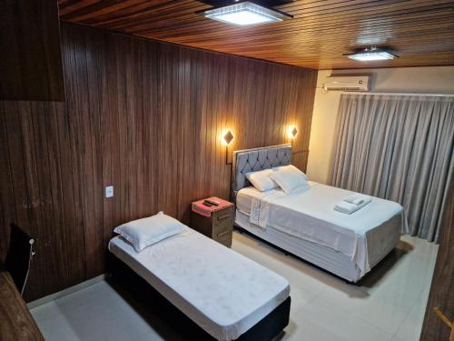- 2 lits dans une chambre dotée de lambris dans l'établissement Casa de campo na cidade, à Foz do Iguaçu