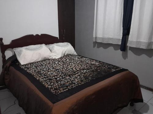 a bed with two pillows on it in a room at DEPARTAMENTO COMODO DUPLEX Zona Norte in Cochabamba