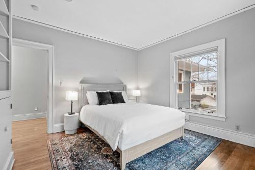 een witte slaapkamer met een groot bed en een raam bij Sapphire Estate in Minneapolis