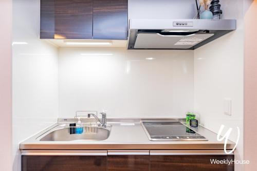 uma cozinha com um lavatório e um fogão forno superior em WeeklyHouse Silto Crete - Vacation STAY 61955v em Otsu