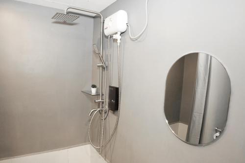 a bathroom with a mirror and a shower at mySTAY Hotel BGC South in Manila