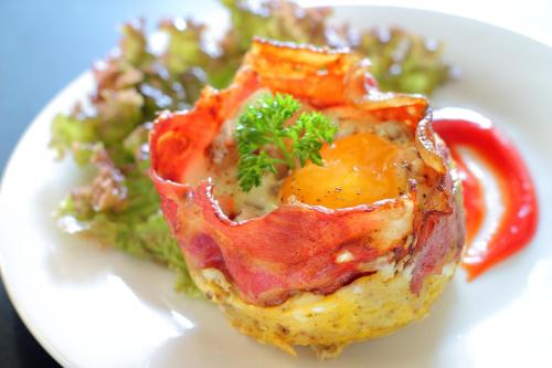 a white plate with a piece of food and a salad at Lotus Tirta Seminyak in Seminyak