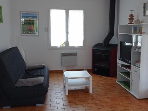 un salon avec un canapé, une télévision et une table dans l'établissement Maison T4 avec Grande Terrasse Couverte, Boulodrome et Jardin Clos - Biscarrosse - FR-1-521-218, à Biscarrosse