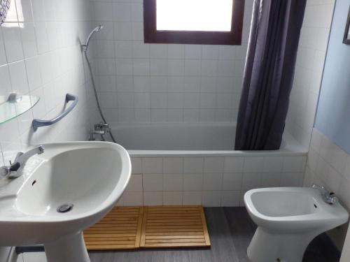 une salle de bain avec un lavabo, une baignoire et des toilettes dans l'établissement Maison T4 avec Grande Terrasse Couverte, Boulodrome et Jardin Clos - Biscarrosse - FR-1-521-218, à Biscarrosse