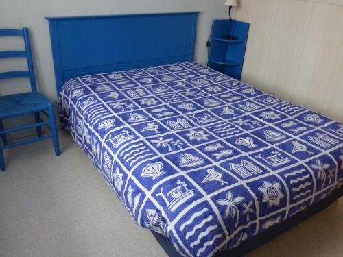 une chambre avec un lit bleu et une chaise bleue dans l'établissement Maison T4 avec Grande Terrasse Couverte, Boulodrome et Jardin Clos - Biscarrosse - FR-1-521-218, à Biscarrosse