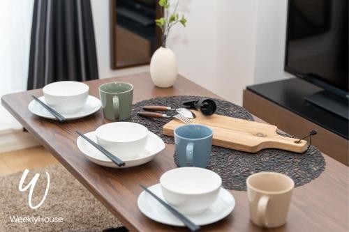a wooden table with plates and cups on it at WeeklyHouse Silto Crete - Vacation STAY 61955v in Otsu