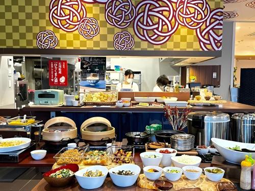 a buffet line of food in a restaurant at Henn na Hotel Kanazawa Korimbo in Kanazawa