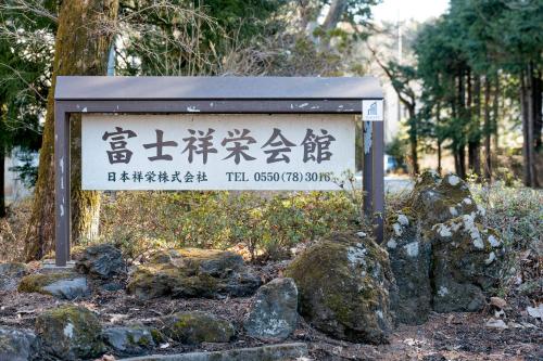 a sign in front of some rocks and trees at 富士祥栄会館 in Oyama